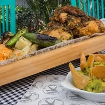Pollo asado presentado sobre tabla de madera